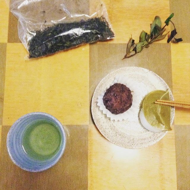 茶の木から枝切ったの右上。香りがね、するんですよ、甘青い香りが^^; 同じ場所で摘んだのを釜炒り茶にしました。少ないので、皆さんと飲もうかと。遅れたこどもの日の気分でおはぎと柏餅でくつろいでます(*^^*) (Instagram)