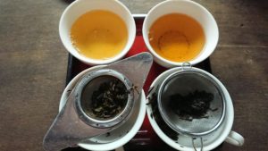 茶こしで越したティーカップのほうじ茶が二つ。液体の色が違います。
