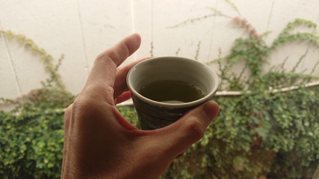 路地に向かってお茶で乾杯